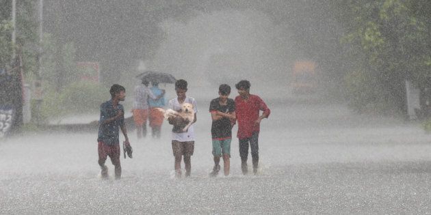 People wade through a flooded street in Kuttanad on 20 August.