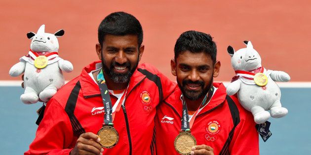 Gold medallists Rohan Manchanda Bopanna and Divij Sharan of India celebrate with their medals and plush mascots at the Asian Games.