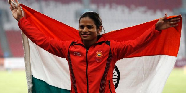 Silver medallist Dutee Chand poses with her national flag during the medal ceremony. REUTERS/Darren Whiteside