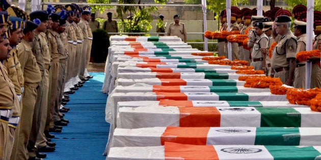 Central Reserve Police Force (CRPF) personnel pay their last respects near the coffins of policemen who died in a Maoist attack, in Raipur, capital of the eastern Indian state of Chhattisgarh June 30, 2010.