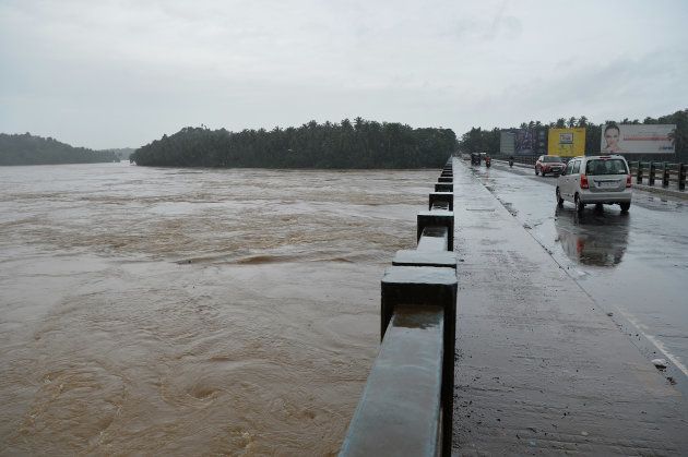 Vehicles drive on a bridge over the overflowing Chaliyar river in Kozhikode, Kerala, on 17 August.