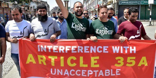 Kashmiri residents hold placards during a two-day strike called by the separatist leaders against the petitions in the Supreme court challenging the validity of Article 35A in Srinagar, Indian administered Kashmir.