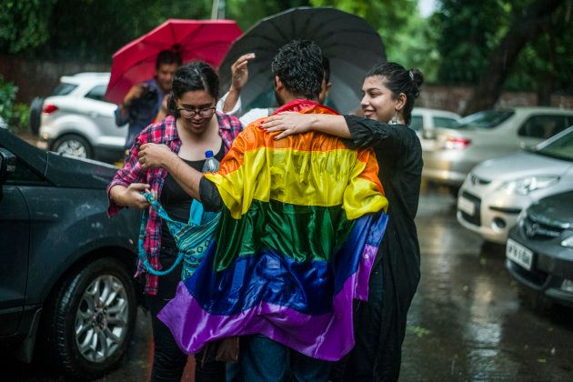 People celebrate on the streets of Delhi despite torrential rain.