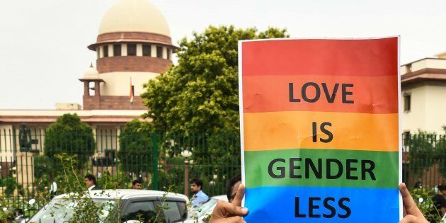 A member of the LGBT community holds a poster outside the Supreme Court in New Delhi after the decision to strike down Section 377.