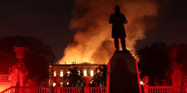 Flames spread behind the Statue of D Pedro II at the Quinta da Boa Vista National Museum.