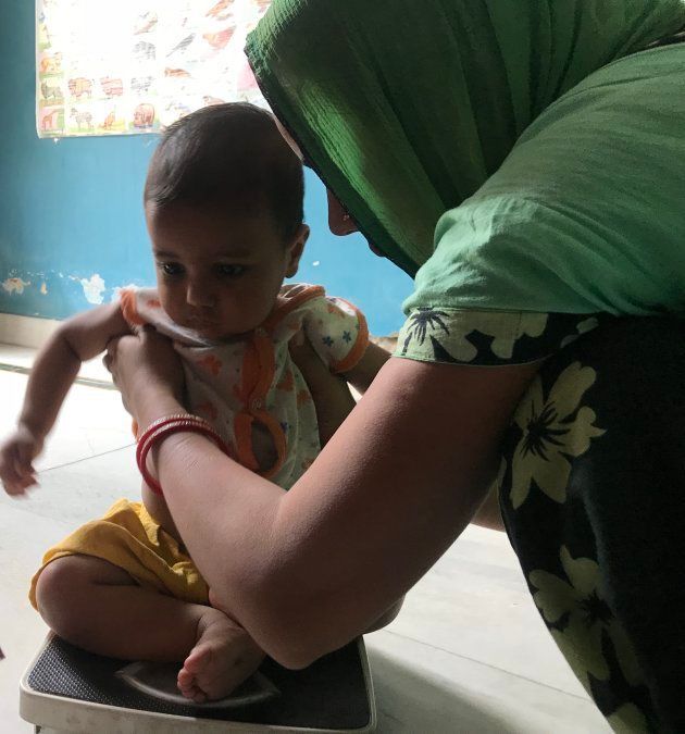 A toddler being weighed at an Anganwadi centre in Delhi