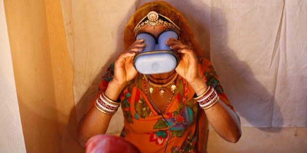 A woman goes through the biometric data collection process to get an Aadhaar card.