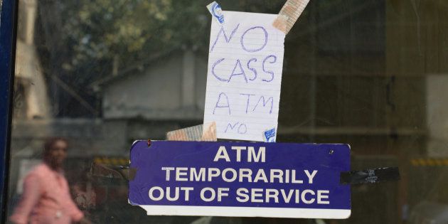 In this photograph taken on November 30, 2016, a handwritten sign stating 'no cash' is hung onto door of an ATM in Mumbai.