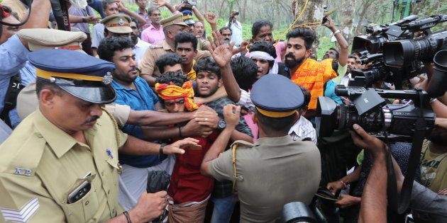 Ratnaamma, a Hindu devotee is surrounded by other devotees as she threatens to commit suicide in protest against the lifting of ban by Supreme Court that allowed entry of women of menstruating age to the Sabarimala temple, at Nilakkal base camp on October 16, 2018 in Pathanamthitta, Kerala.