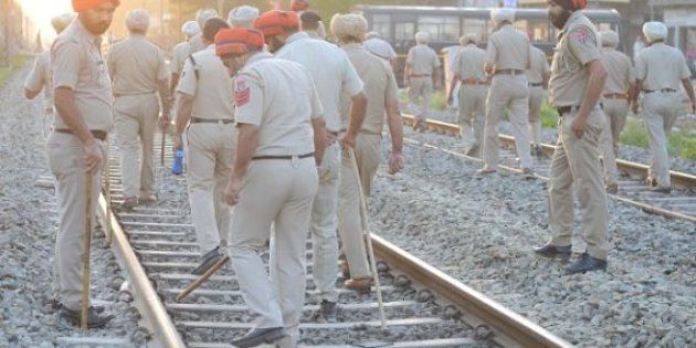 Indian Punjab Police personnel walk at the scene of the accident along railroad tracks in Amritsar on October 20, 2018, after revellers who gathered on the tracks were killed by a moving train on October 19. - A speeding train ran over revellers watching fireworks during a Hindu festival in northern India Friday, killing more than 50 people, with eyewitnesses saying they were given no warning before disaster struck. (Photo by NARINDER NANU / AFP) (Photo credit should read NARINDER NANU/AFP/Getty Images