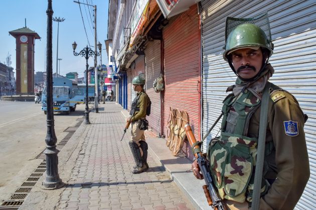 Army men stand guard on the deserted streets of Srinagar on Monday.