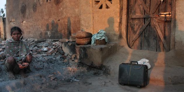 A victim of the 2011 police raid in Tadmetla with all that remains of her possessions.