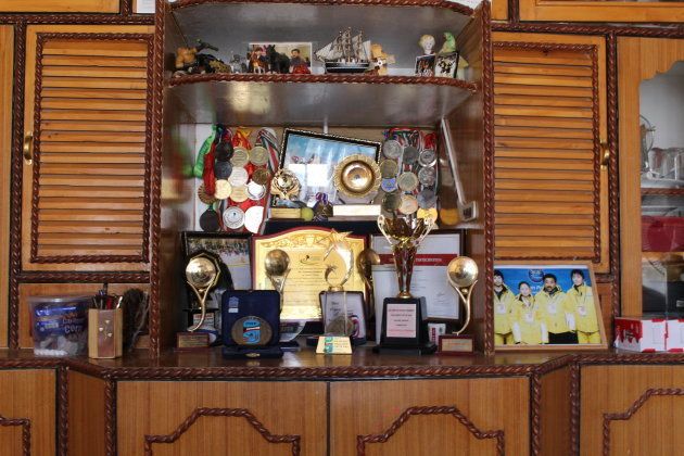 A growing collection of trophies, medals, and photos crowd the shelves of a cabinet in the living room of Disket Angmo's mother in Leh. (Photo: Sam Goldman)