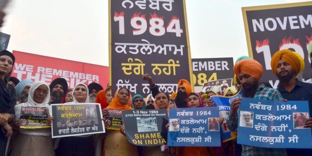Activists participate in a candle march demanding justice for those who were killed in the 1984 anti-Sikh riots.