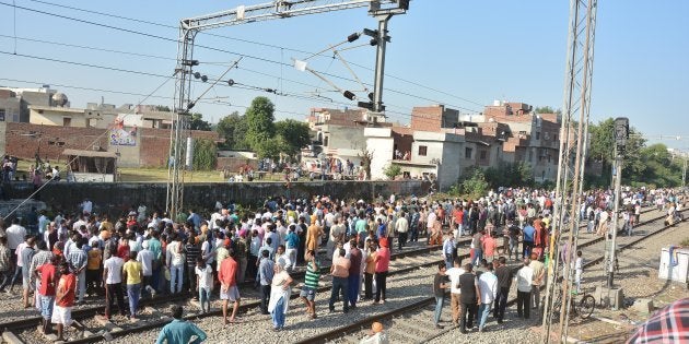 Punjab Police personnel and local people at the scene of the accident along train tracks.