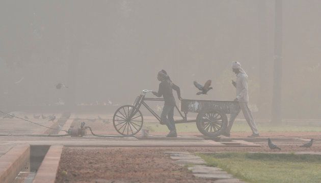 NEW DELHI, INDIA - NOVEMBER 20: Labourers work early in the morning amid heavy smog at Humayun's Tomb on November 20, 2018 in New Delhi, India. The overall air quality index was recorded at 352, which falls in the 'very poor' category, according to Central Pollution Control Board data. (Photo by Biplov Bhuyan/Hindustan Times via Getty Images)