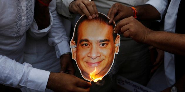 Congress activists burn a cutout of Nirav Modi during a protest in Mumbai.