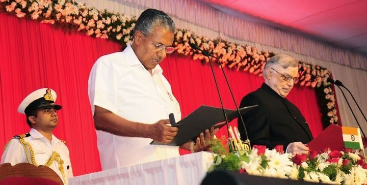 Incoming Chief Minister of Kerala Pinarayi Vijayan (C) stands alongside Governor of Kerala P. Sathasivam(R) as he takes part in a swearing-in ceremony in Thiruvananthapuram on May 25, 2016.