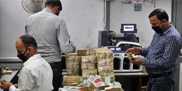 Bank employees count old ₹500 banknotes inside a bank.