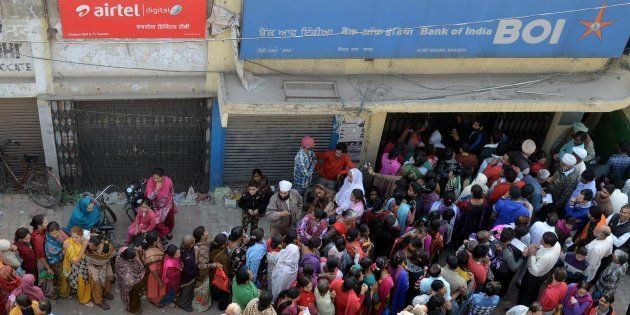 People queue outside a bank as they wait to deposit and exchange ₹500 and ₹1,000 notes in Amritsar on 13 November 2016.