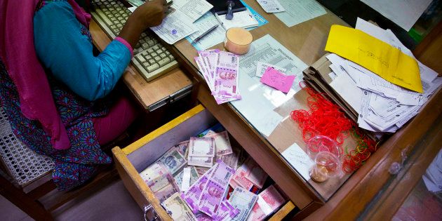 A bank employee counts discontinued currency notes while working at a currency exchange counter at a bank in Gauhati, India, Friday, 11 Nov, 2016.