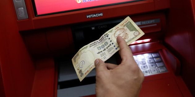 A customer deposits 500 Indian rupee banknote in a cash deposit machine in Mumbai, India, November 8, 2016. REUTERS/Danish Siddiqui
