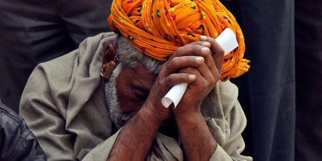 File photo of a man sitting in a queue to deposit his old high denomination notes in Ajmer.