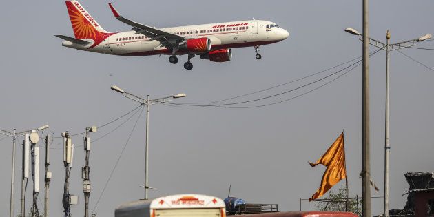 An Air India Ltd. aircraft passes over traffic as it prepares to land at Chhatrapati Shivaji International Airport in Mumbai.