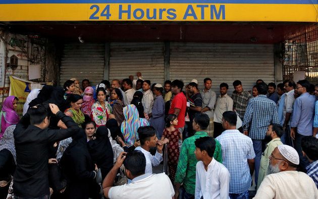 People queue outside a bank to withdraw cash and deposit their old high denomination banknotes in Mumbai, India, December 2, 2016.