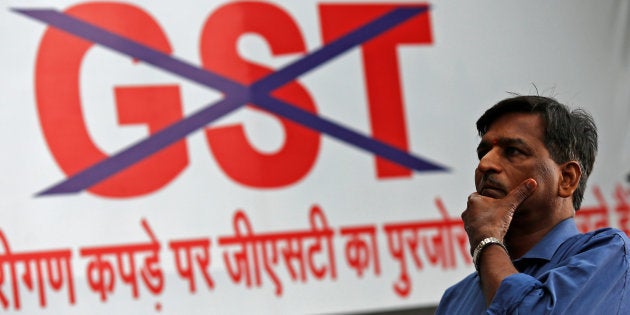 A man walks past a banner during a protest by traders against the implementation of the Goods and Services Tax (GST), in the old quarter of Delhi, India June 30, 2017. REUTERS/Adnan Abidi