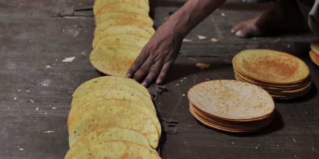 An Indian worker arranges khakra at a food factory.