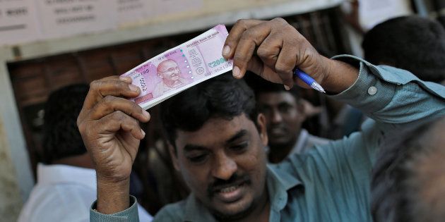 A man holds 2000 Indian rupees notes as he gets out of a bank in Mumbai, India, November 24, 2016. REUTERS/Danish Siddiqui