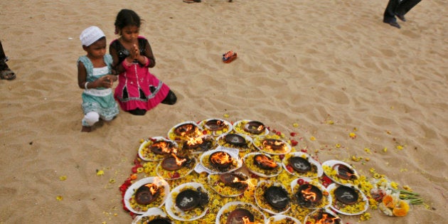 Young Indian kids offer prayers at Marina beach, that was hit by the 2004 tsunami, in Chennai, India, Wednesday, Dec. 26, 2012. The Dec. 26, 2004 tsunami killed an estimated 230,000 people in 12 Indian Ocean nations, from Thailand to Sri Lanka. (AP Photo/Arun Sankar K.)