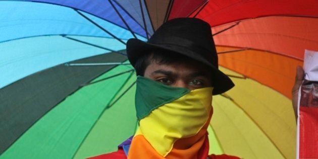 A participant holds an umbrella with rainbow colors as members of the Lesbian, Gay, Bisexual, Transgender (LGBT) community and their supporters from across India participate in a pride walk in Surat in Gujarat state, India, Sunday, Oct. 6, 2013. The walk was organized for the first time in the Gujarat state demanding social acceptance and equal rights. (AP Photo/Ajit Solanki)