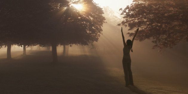 Woman practicing yoga in foggy field