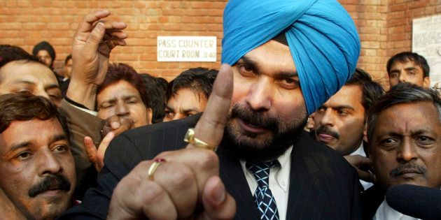 Former Indian cricketer and lawmaker Navjot Singh Sidhu (C) gestures to the media outside a court in Chandigarh December 6, 2006.