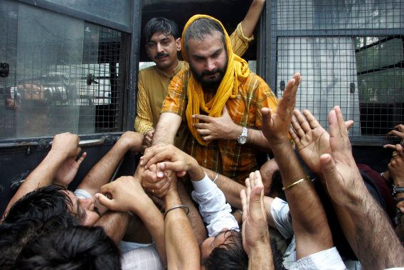 Navjot Singh Sidhu, lawmaker from India's main opposition Bharatiya Janata Party (BJP) and a former cricket player, holds hands of his party workers as he is arrested by police after the clashes between police and BJP party workers during a protest against fuel price hikes in the northern Indian city of Chandigarh June 23, 2008. REUTERS/Ajay Verma