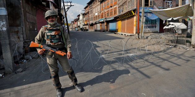 An Indian policeman stands guard in a deserted street during a curfew in Srinagar July 12, 2016. REUTERS/Danish Ismail