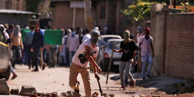 A demonstrator hurls a stone towards Indian police during a protest in Srinagar against the recent killings in Kashmir, July 28, 2016.
