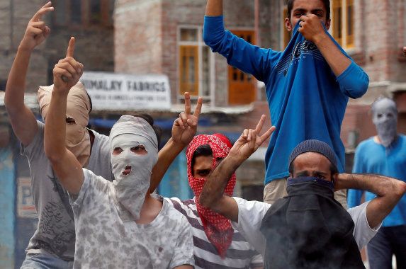 Masked demonstrators shout slogans during a protest in Srinagar against the recent killings in Kashmir, July 26, 2016.