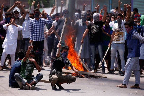 Protesters hold sticks as they shout slogans during a protest in Srinagar against the recent killings in Kashmir, July 23, 2016.