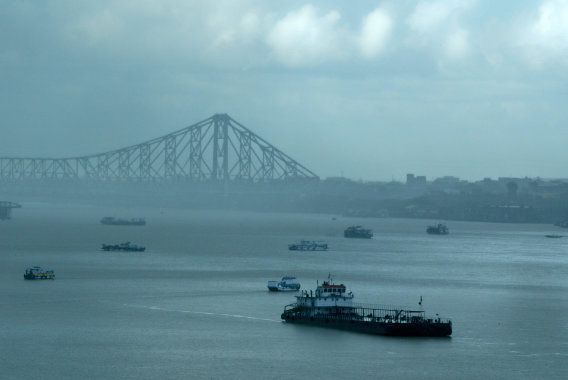 A passenger boat moves along the Hooghly river after passing under the Howrah bridge during a monsoon shower in Kolkata.