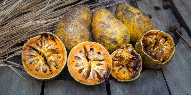 advantage of bael fruit or quince as fruit, medicine, glue on wooden background