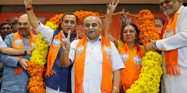 Vijay Rupani, second left, state president of Bharatiya Janata Party (BJP) in Gujarat, is garlanded as he is selected as Chief Minister of the state, along with Nitin Patel, third left, in Gandhinagar, India, Friday, Aug. 5, 2016. Patel will take over as Deputy Chief Minister. (AP Photo/Ajit Solanki)