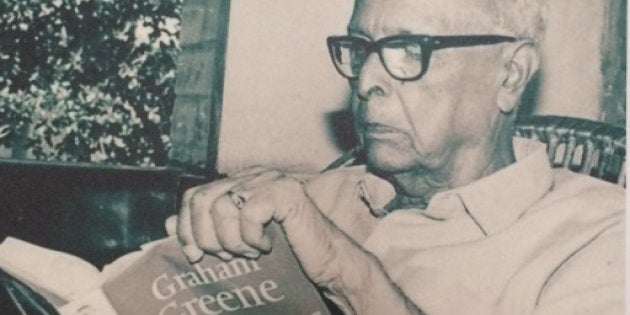 Photograph of a photo of R.K. Narayan reading Graham Greene.