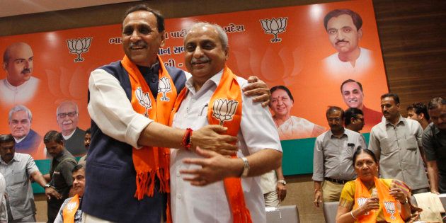 Vijay Rupani, left, state president of Bharatiya Janata Party (BJP) in Gujarat, is congratulated by Nitin Patel as he is selected as Chief Minister of the state in Gandhinagar, India, Friday, Aug. 5, 2016. Patel will take over as Deputy Chief Minister. (AP Photo/Ajit Solanki)