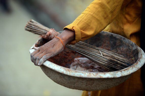 In this picture taken on August 10, 2012, shows a manual scavenger carrying tools of her profession, a basket, a broom and plastic shovel, while on her way to clean dry toilets in Nekpur village, Muradnagar in Uttar Pradesh.