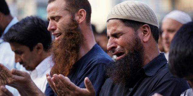 A man cries as others offer prayers on a road as a protest in Srinagar against the recent killings in Kashmir, July 30, 2016.