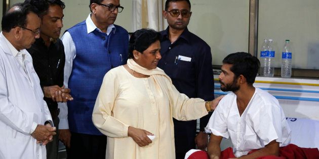 India's Bahujan Samaj Party or BSP chief Mayawati, center, talks to Ramesh Sarvaiya, a low-caste Dalit victim who was allegedly attacked by men claiming to be cow protectors, at a civil hospital in Ahmadabad, India, Thursday, Aug. 4, 2016.