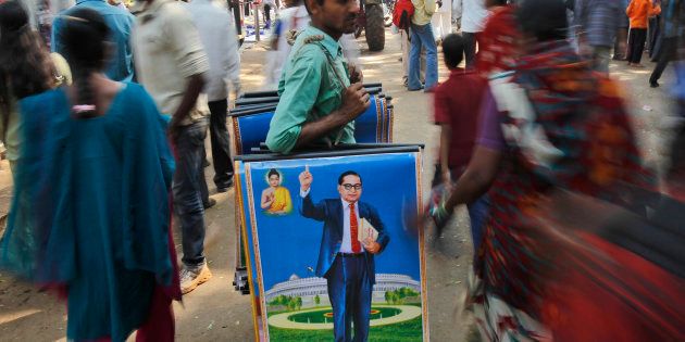 A man holds posters of B.R. Ambedkar for sale on his death anniversary in Mumbai, on 6 December 2011. (AP Photo/Rafiq Maqbool)